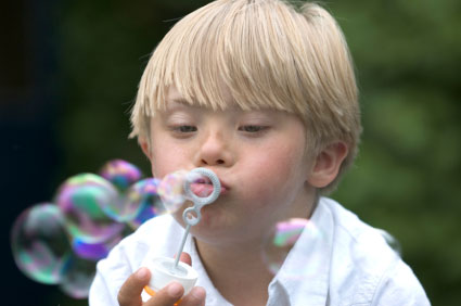 Downs-Syndrome boy blowing bubbles